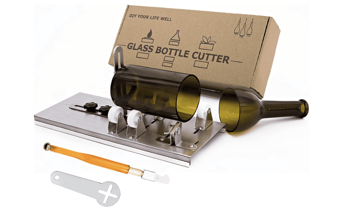 The glass bottle cutter kit features a cutting tool, adjustable base with rollers, and a small handheld cutter. Perfect for crafting wine bottle candles, it comes in a cardboard box labeled "DIY Your Life Well, Glass Bottle Cutter.